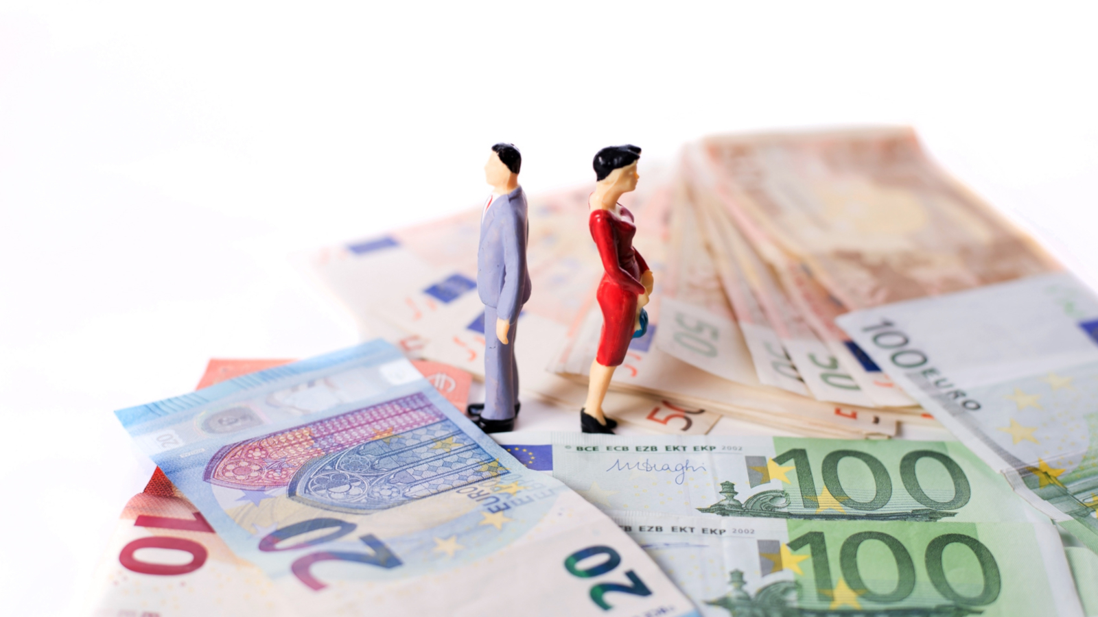 Miniaturfiguren, Mann und Frau, stehen auf Geldscheinen