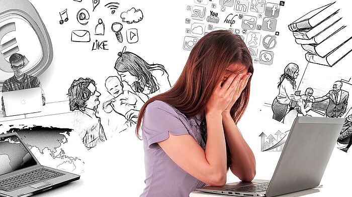 Frau sitzt vor Laptop und schlägt sich Hände vor das Gesicht