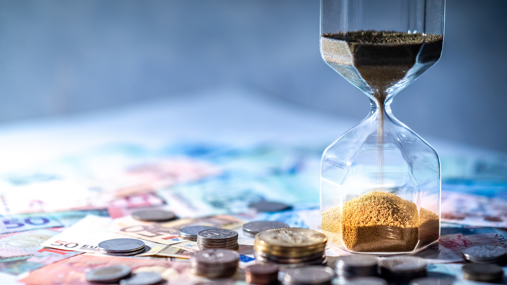 Sanduhr und Geld auf dem Tisch