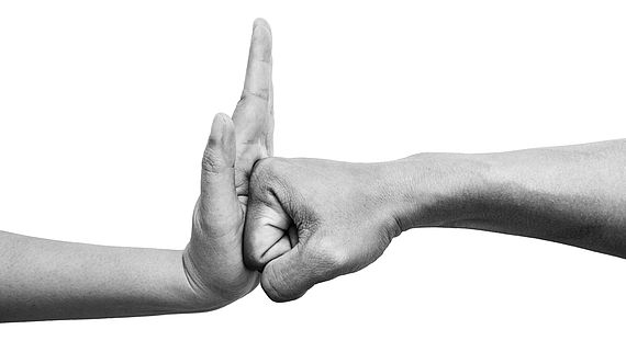 Frau benutzt Handfläche, um den Schlag des Mannes vom Angriff abzuhalten