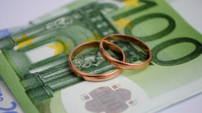 Einhundert Euro Geldschein mit zwei Eheringen