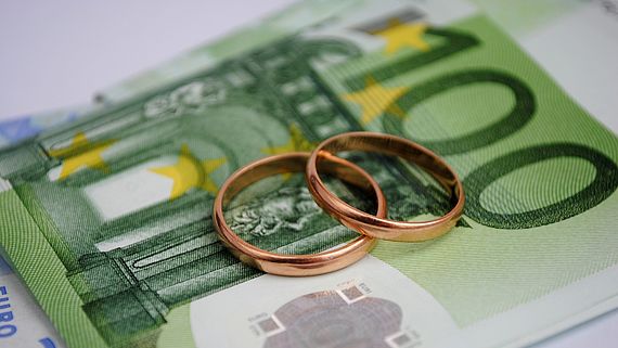 Eheringe liegen auf Geldscheinen