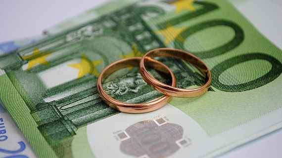 Eheringe liegen auf Geldscheinen