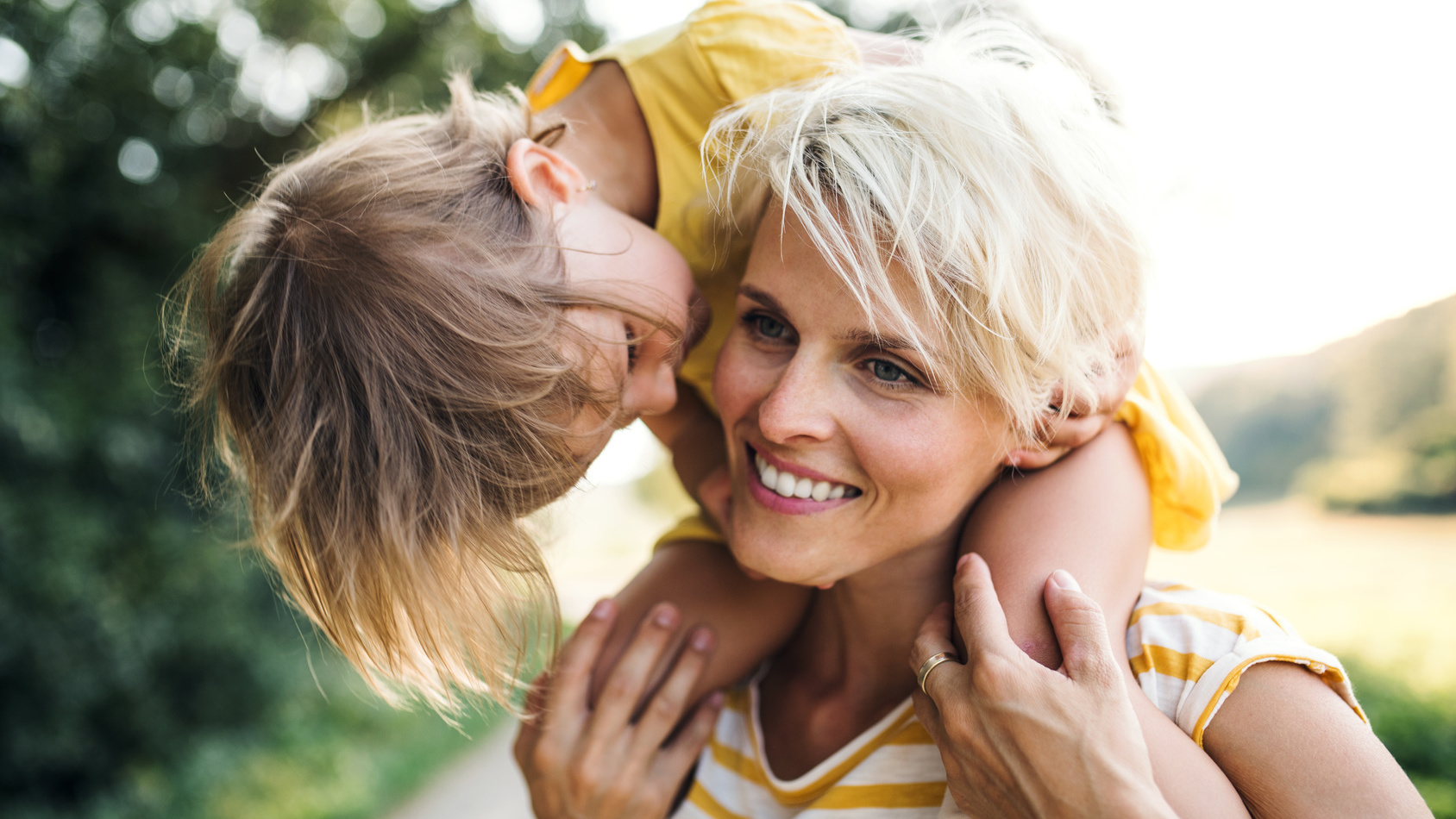 Kleines Kind sitzt bei seiner Mutter auf den Schultern
