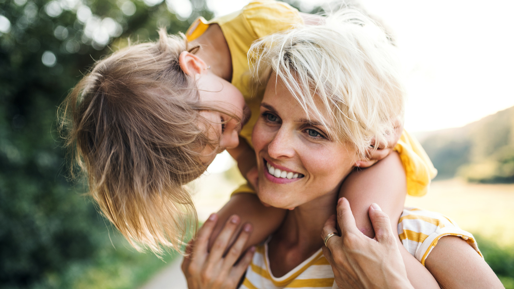 Kleines Kind sitzt bei seiner Mutter auf den Schultern