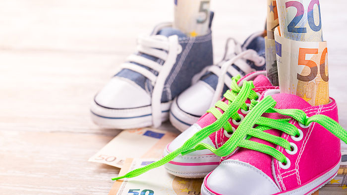 Kinderschuhe mit Geldscheinen